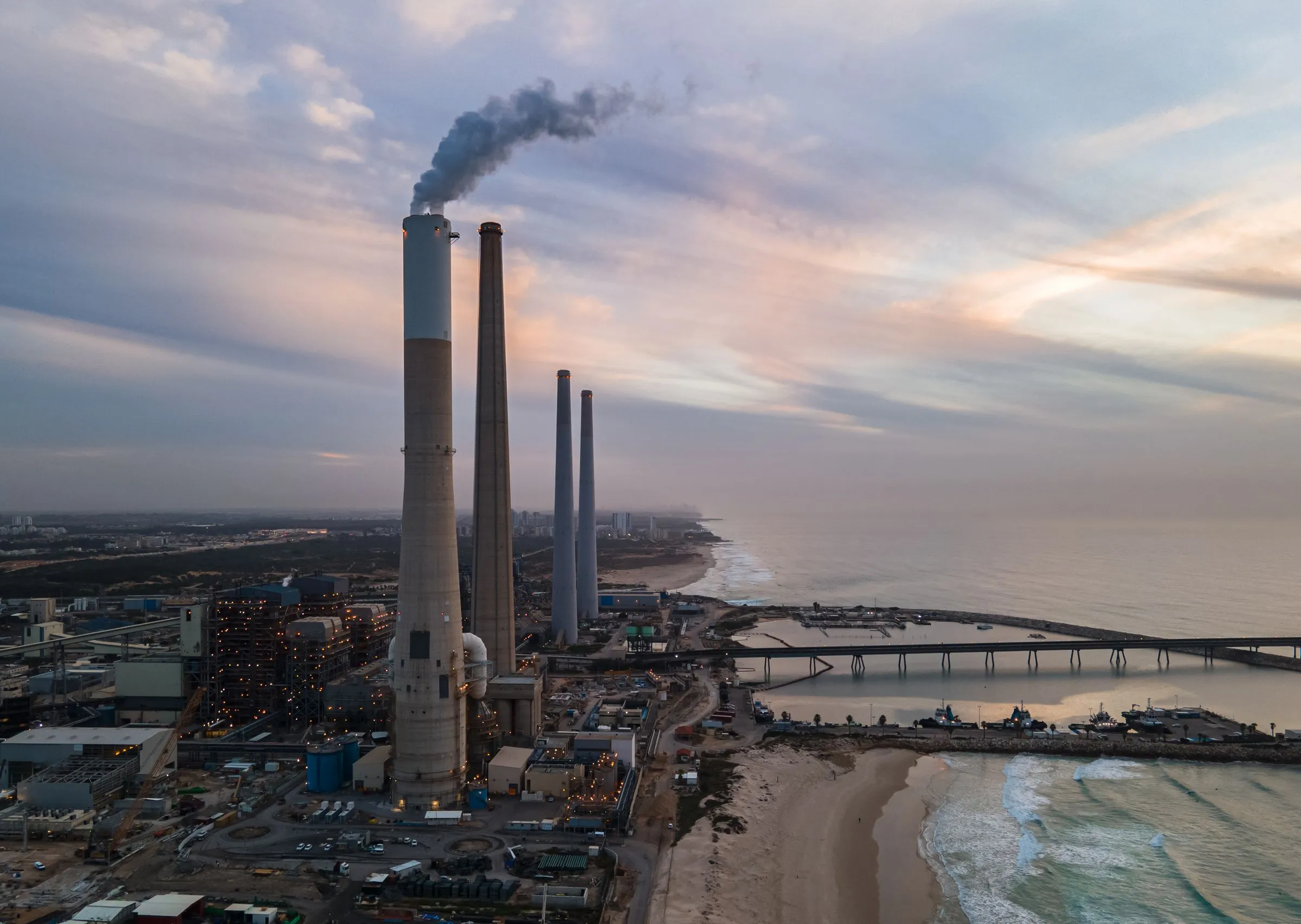 Aerial view of an industrial plant on the coast at sunset